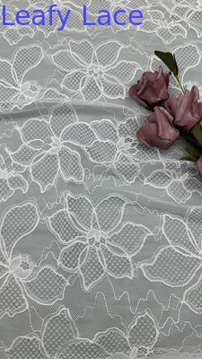 Tessuto ricamato in pizzo bianco con motivi floreali su base a rete per abiti da sposa