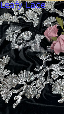 Tessuto in tulle nero floccato con foglie, pizzo, paillettes e dettagli argentati per abiti formali importanti